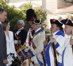 Don Felipe y Doña Letizia con voluntarios vestidos de época durante su visita