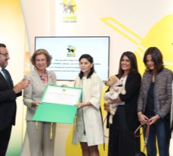 Su Majestad la Reina Doña Sofía, acompañada por Miguel Carballeda, tras la entrega del diploma a Teresa Domínguez de la Parra, su esposo y sus hijas