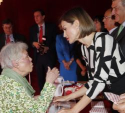 Su Majestad la Reina conversa con una señora que hizo un donativo a Cruz Roja