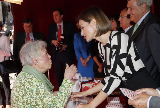 Su Majestad la Reina conversa con una señora que hizo un donativo a Cruz Roja