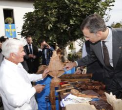 Don Felipe observa una de las piezas elaboradas en madera