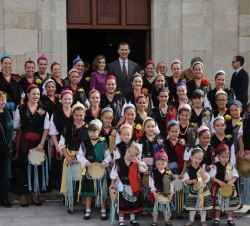 Los Reyes con un grupo de mujeres y niñas vestidas con trajes de llanisca, en la Iglesia de Santa María de Colombres