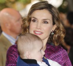 Doña Letizia, con un niño en brazos, durante su saludo a los vecinos de la localidad