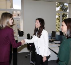 Doña Letizia saluda a los trabajadores de la Fundación Microfinanzas BBVA durante su recorrido por las instalaciones.