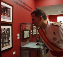 Su Majestad el Rey observa una fotografía familiar realizada en su etapa de guardiamarina a bordo del buque-escuela "Juan Sebastián Elcano"