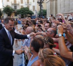 Sus Majestades los Reyes reciben el saludo de las personas que esperaban a su llegada al Palacio de La Almudaina  