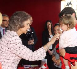 Doña Sofía saluda cariñosamente a un niño que acudió a la mesa de cuestación