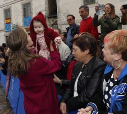 Doña Letizia abraza a una niña durante su saludo a los vecinos de San Martín de Oscos
