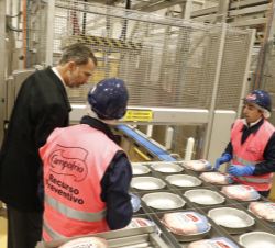 Su Majestad el Rey conversa con dos trabajadores a su paso por la zona de empaquetado y expedición del producto final