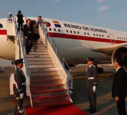 Sus Majestades los Reyes descienden por la escalerilla del avión a su llegada a Japón