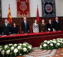 Sus Majestades los Reyes durante la interpretación del Himno Nacional, al comienzo del acto
