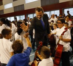 Momento en el que Don Felipe choca la mano con uno de los niños de la orquesta
