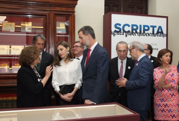 Sus Majestades los Reyes atienden a las explicaciones de la comisaria de la muestra, Margarita Becedas, durante su recorrido por la exposición