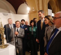 Sus Majestades los Reyes contemplan una de las obras expuestas en la muestra