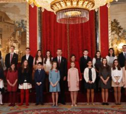 Fotografía de grupo de Sus Majestades los Reyes con la Princesa de Asturias y la Infanta Sofía con niños ganadores de las tres últimas ediciones del c
