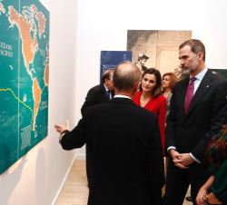 Sus Majestades los Reyes durante el recorrido por una exposición de paneles, con explicaciones a cargo de los comisarios