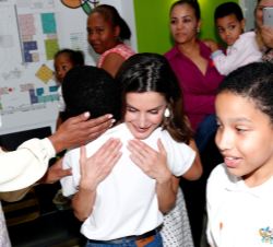 SSu Majestad la Reina abraza a un niño del Centro de Atención Integral para la Discapacidad durante su visita