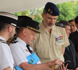 Su Majestad el Rey durante el desarrollo de las prácticas de exhibición conversa con el representante de la Gendarmería Nacional Francesa