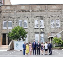 Sus Majestades los Reyes ante la fachada del edificio Magik Theatre acompañados por el artista Daniel Muñoz y las autoridades asistentes al acto