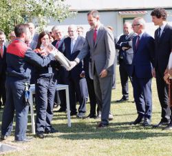 Don Felipe entrega el tubo con dos periódicos, una moneda en curso e información de la empresa a un operario para colocarla en el hueco de la primera 