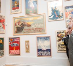 Su Majestad el Rey observa los cuadros de la exposición durante su visita