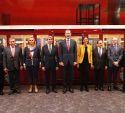 Fotografía de grupo de Su Majestad el Rey con las autoridades y personalidades, ante un coche histórico que realizó el primer recorrido de la Línea-1
