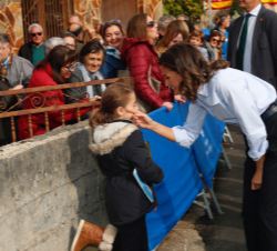 Su Majestad la Reina saluda a una niña durante el recorrido