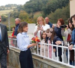 Su Majestad la Reina recibe un ramo de flores de unas niñas durante el recorrido por Mual
