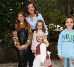 Su Majestad la Reina junto a unos niños durante la visita al Premio Princesa de Asturias al Pueblo Ejemplar