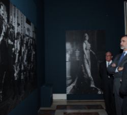 Su Majestad el Rey observa una de las fotografías en las que aparece el Rey Alfonso XIII