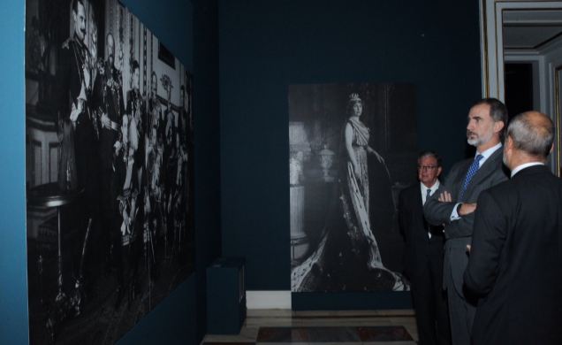 Su Majestad el Rey observa una de las fotografías en las que aparece el Rey Alfonso XIII