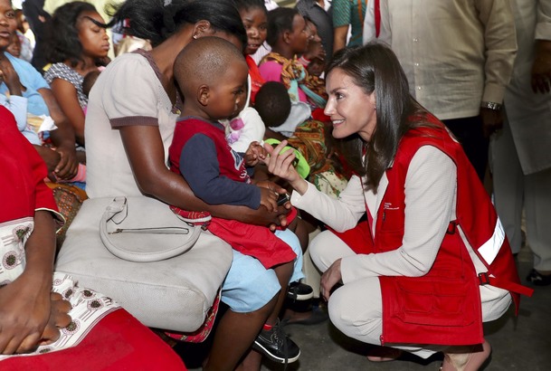 Su Majestad la Reina saluda cariñosamente a uno de los niños durante su visita al Centro de Salud de Manhiça