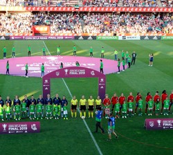 Los equipos de fútbol femenino del Atlético de Madrid y la Real Sociedad durante la interpretación del Himno Nacional