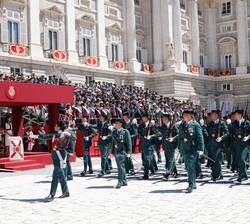 Sus Majestades los Reyes durante el desfile terrestre al paso de componentes de la Guardia Civil