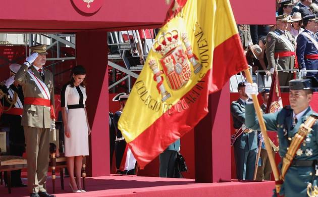 Sus Majestades los Reyes durante el desfile terrestre al paso de la Enseña Nacional