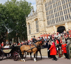 Sus Majestades los Reyes junto a Sus Altezas Reales los duques de Cambridge en un coche de caballos descubierto tras la ceremonia de investidura como 