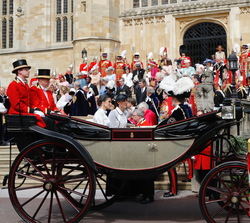 Sus Majestades los Reyes junto a Sus Altezas Reales los duques de Cambridge en un coche de caballos descubierto