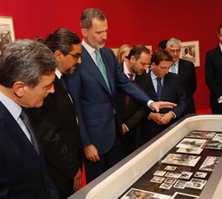 Don Felipe comenta las fotografías de la vitrina con el comisario de la exposición