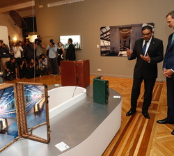 Su Majestad el Rey durante su recorrido, ante una maletas con imágenes de la exposición