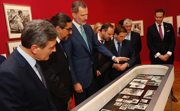 Don Felipe comenta las fotografías de la vitrina con el comisario de la exposición