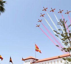 La Patrulla Águila realiza la Bandera Española a su paso por la tribuna durante el desfile aéreo