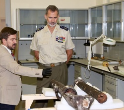 Su Majestad el Rey observa una de las piezas en restauración