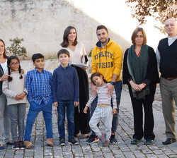 Fotografía de Su Majestad la Reina junto al grupo de escolares que le entregaron unos trabajos