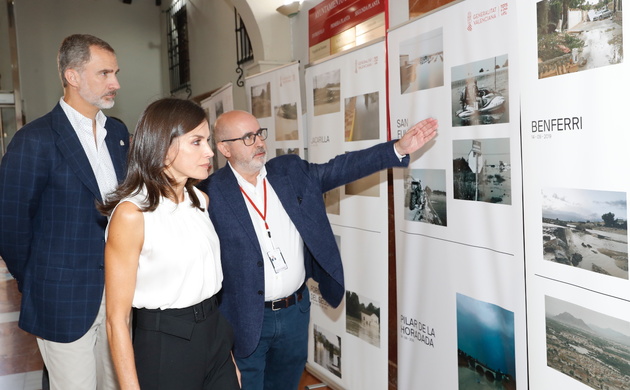 Sus Majestades los Reyes observan la exposición fotográfica sobre los daños ocasionados por las inundaciones en la Vega Baja del Segura