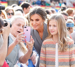 Su Majestad la Reina junto a Su Alteza Real la Princesa de Asturias haciendose un selfi con el público