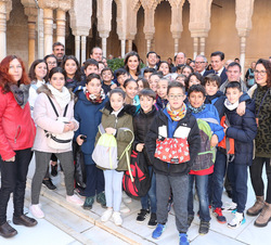Su Majestad la Reina junto a un grupo de escolares que también realizaban la visita