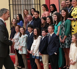 Su Majestad el Rey pasa a ocupar su puesto en la fotografía de grupo de alumnos y profesores tras saludarles