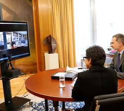 Su Majestad el Rey durante la videoconferencia acompañado por la ministra de Asuntos Exteriores, Unión Europea y Cooperación, Arancha González Laya