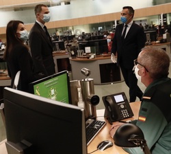 Sus Majestades los Reyes conversan con un agente de la Guardia Civil en el puesto de mando