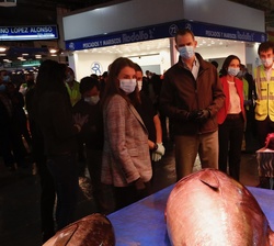 Don Felipe y Doña Letizia conversan con un empleado de un puesto en la nave del mercado de pescados y mariscos